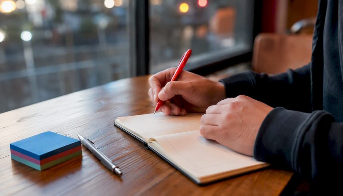 Hands preparing writing task notes on blank paper