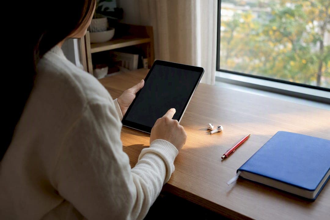 Hands holding tablet with blank screen