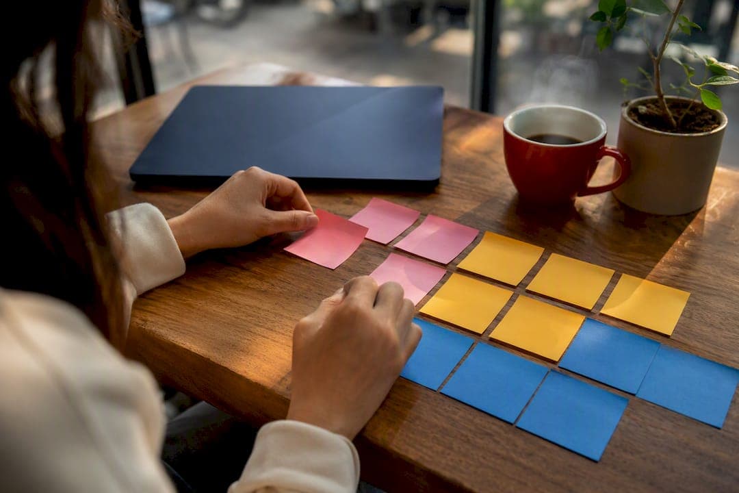 Hands arranging vocabulary sticky notes at a desk